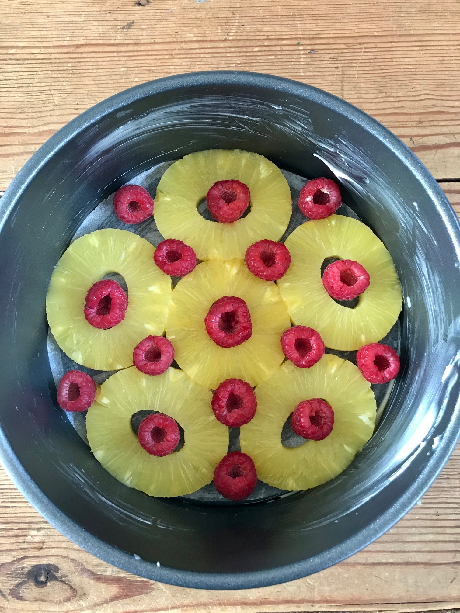 Pineapple and raspberries on the bottom of a big bowl.
